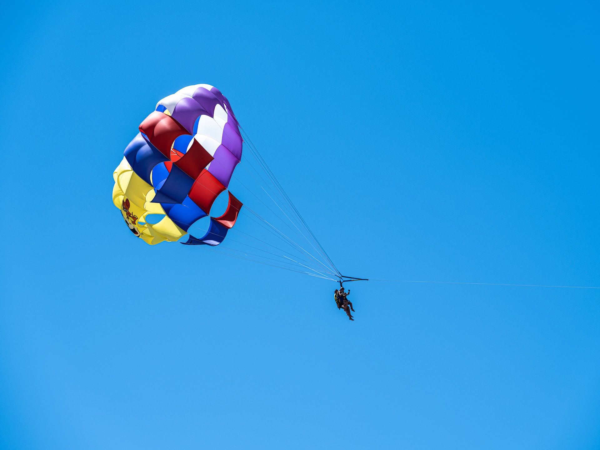 Tourists parasailing in blue sky 
