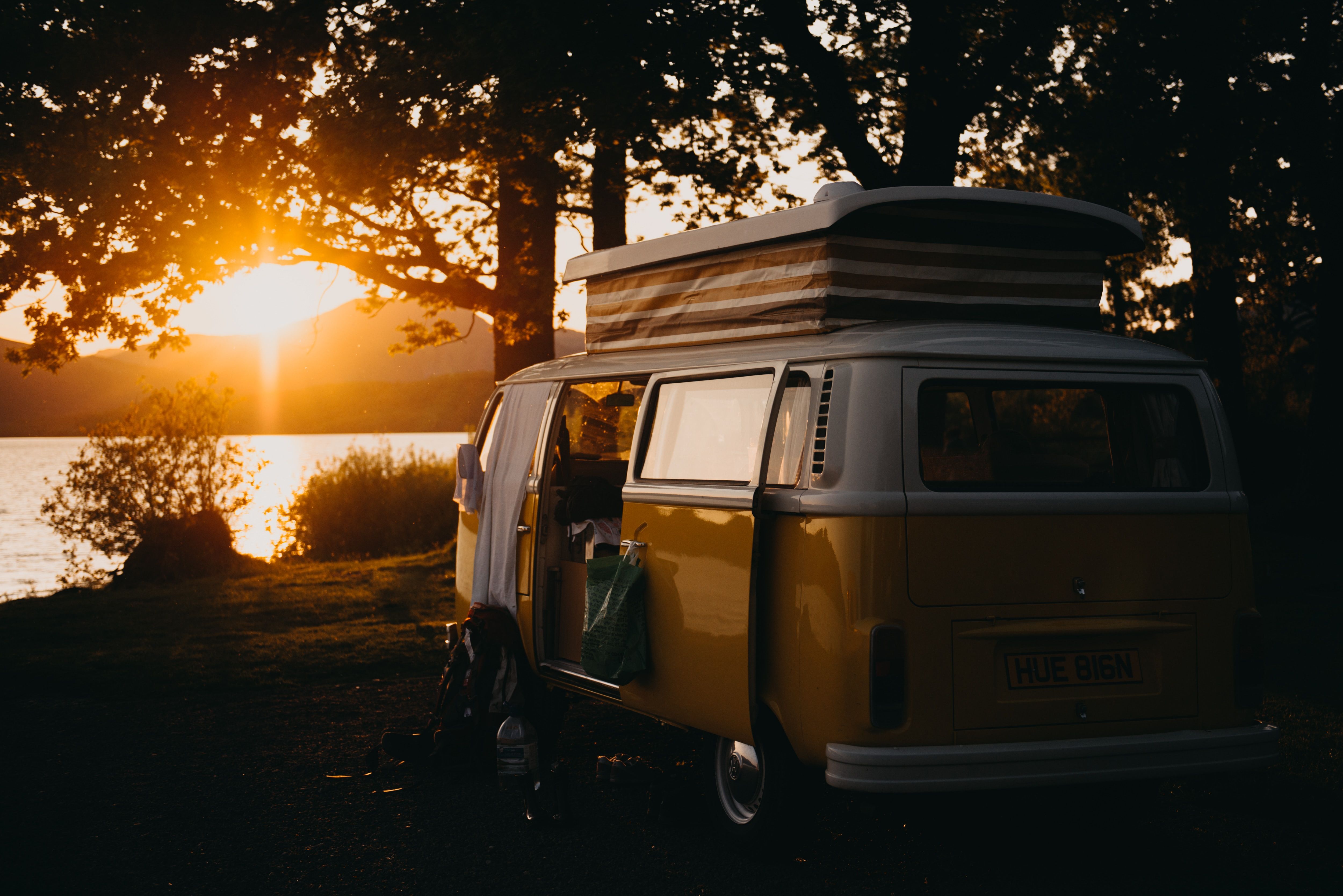 Camping van overlooking water at sunset