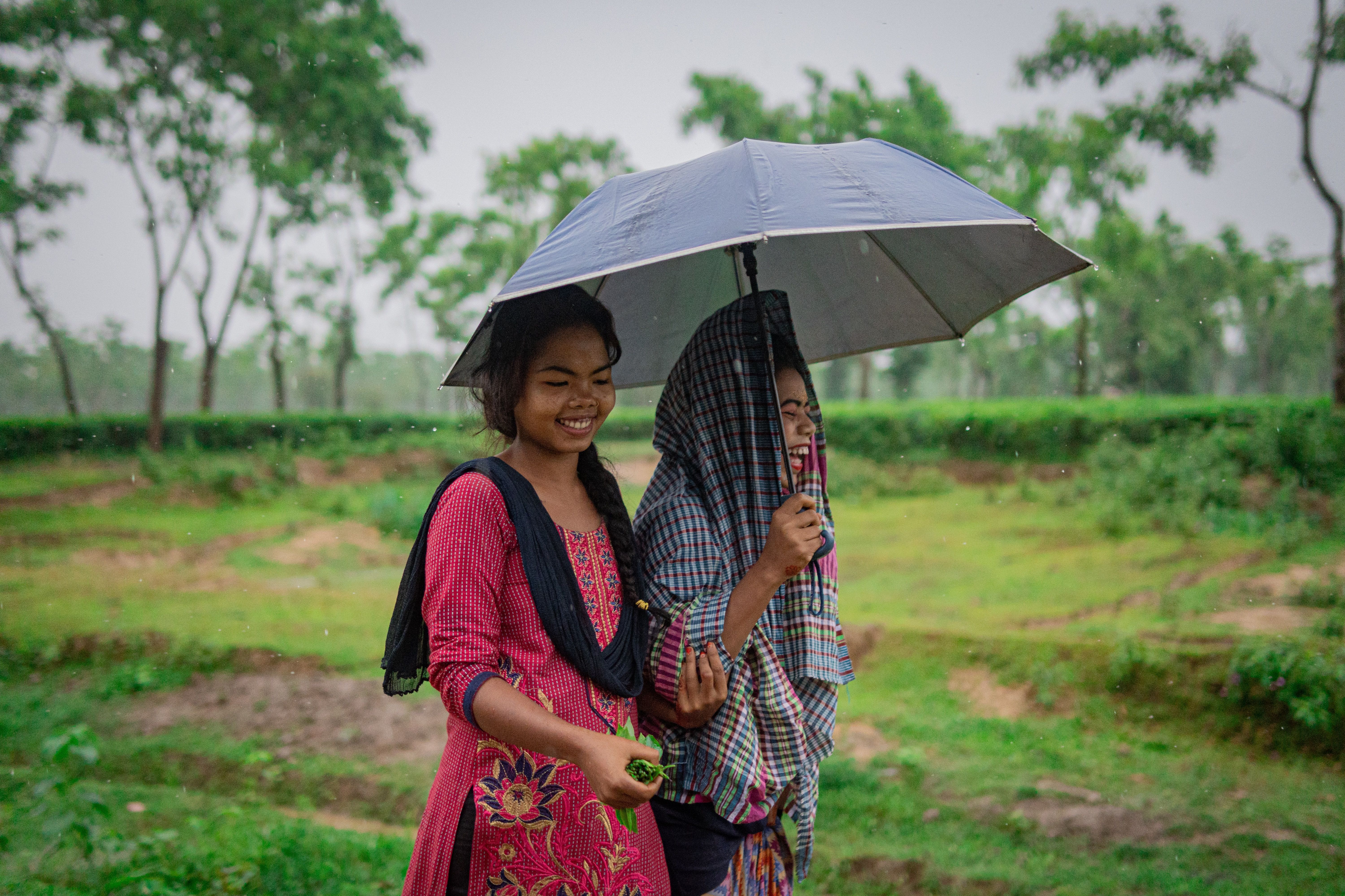 Two women walking under an umbrella 