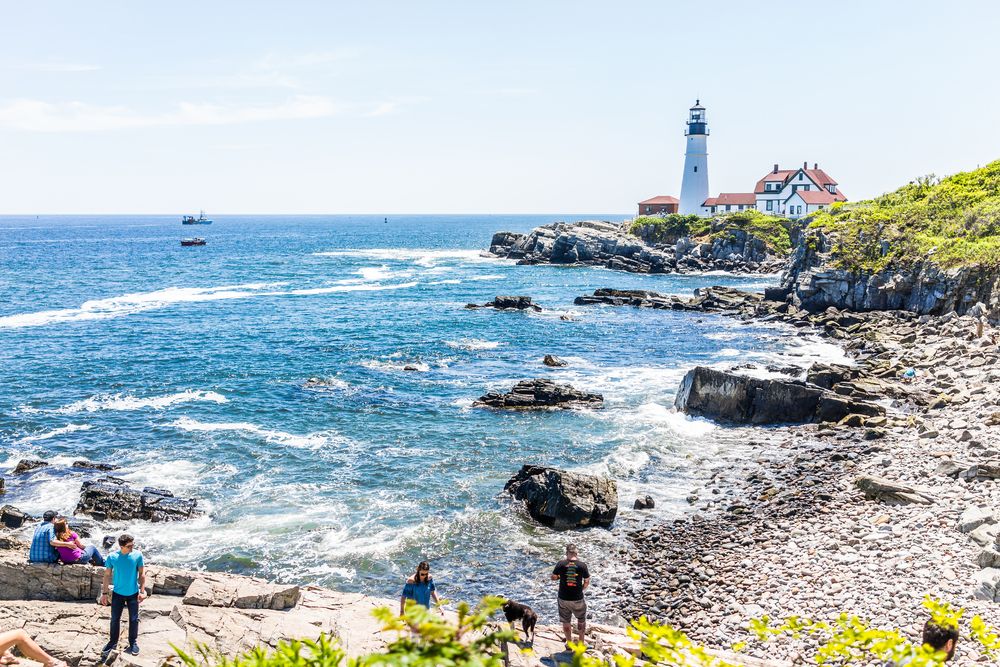 Portland Head Lighthouse and tourists in Fort Williams park in Maine