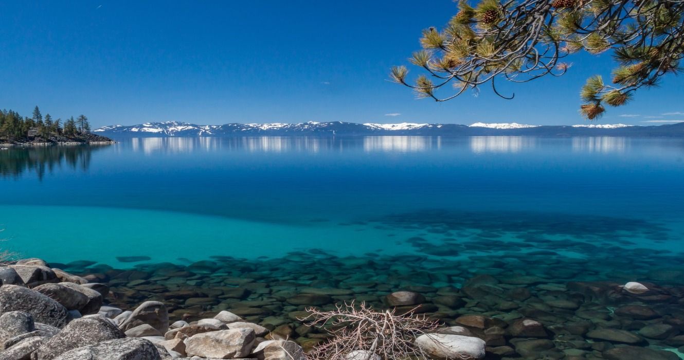 The clear blue waters of Lake Tahoe in California with the mountains in the distance