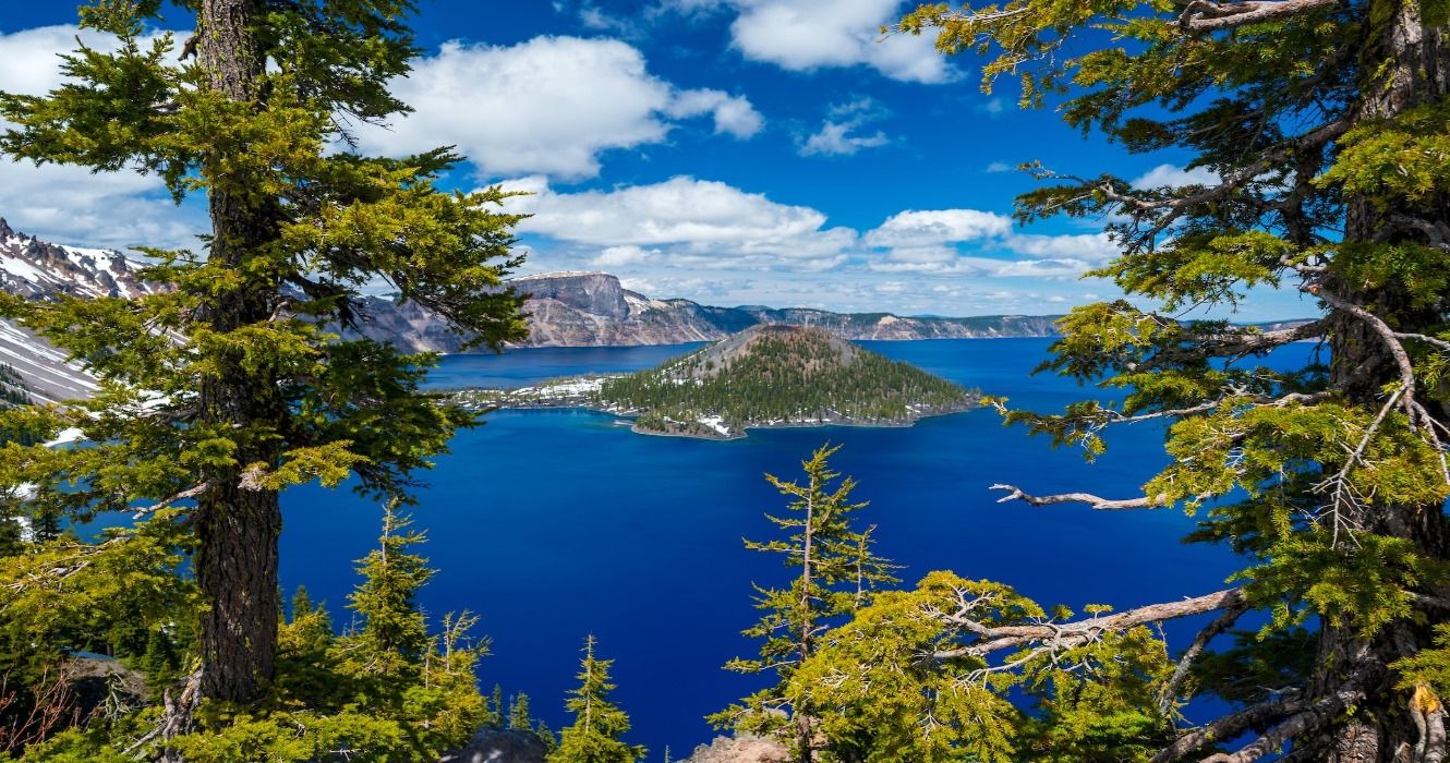 A view of Crater Lake in Oregon, USA, from between the green treees