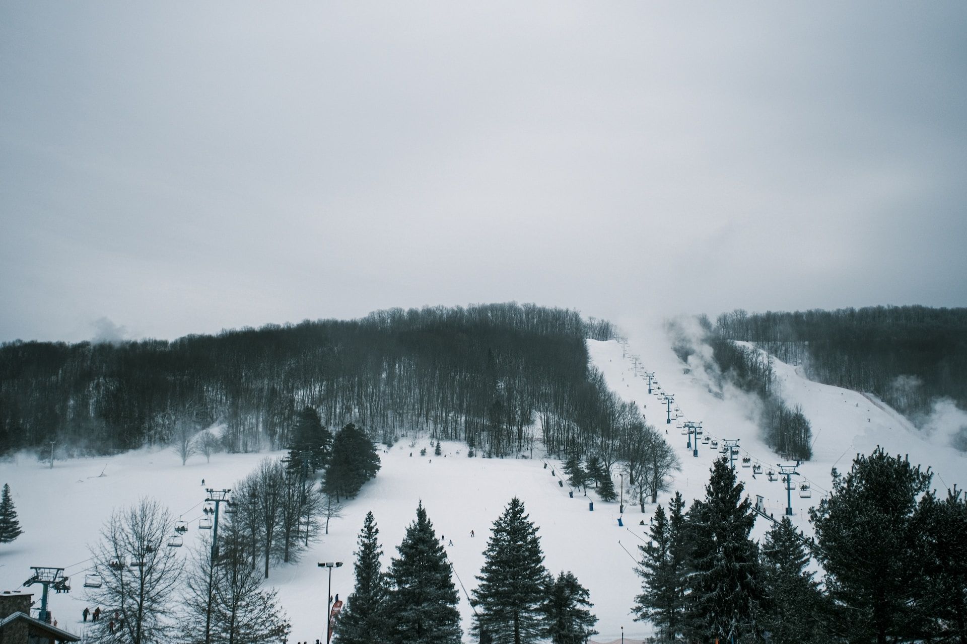 Skiers going up a snowy slope in cablecarts near Ellicottville