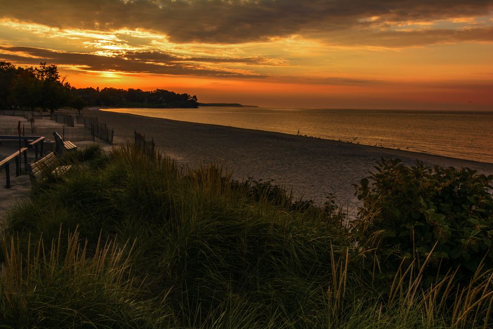 A beautiful warm sunset at the Sodus Bay beach park in New York, on the shore of Lake Ontario.