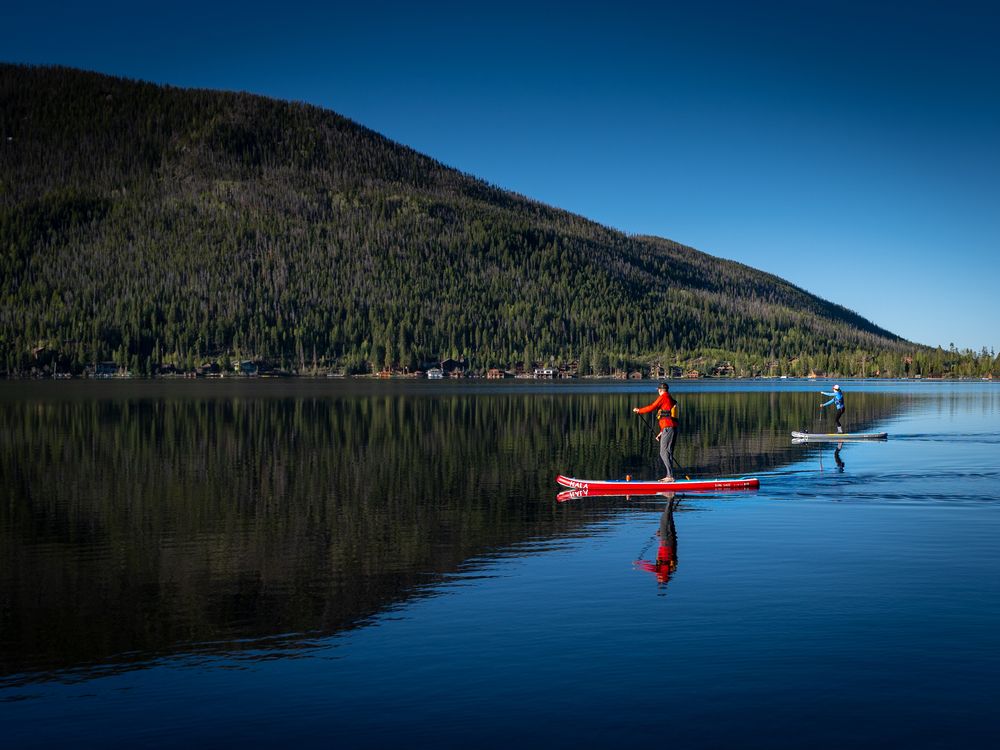 A person stand up paddle boarding at Grand Lake, Colorado, USA