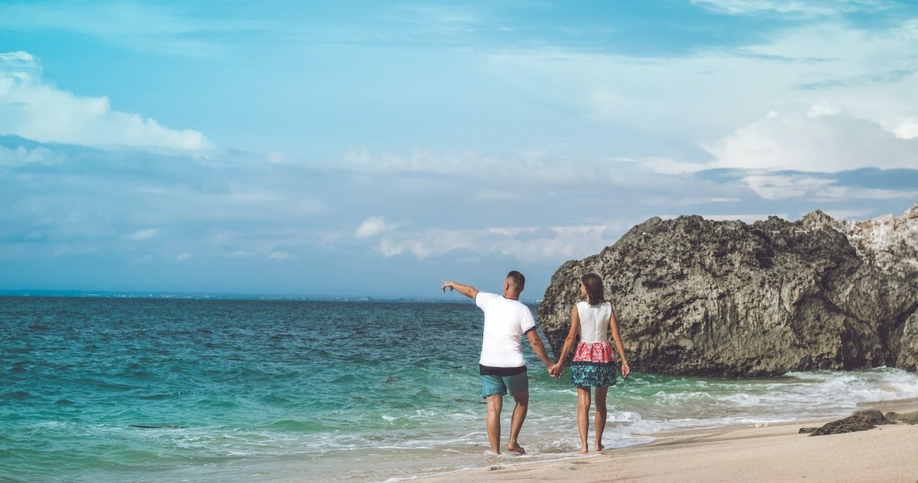 A couple walking along the beach in Bali Indonesia