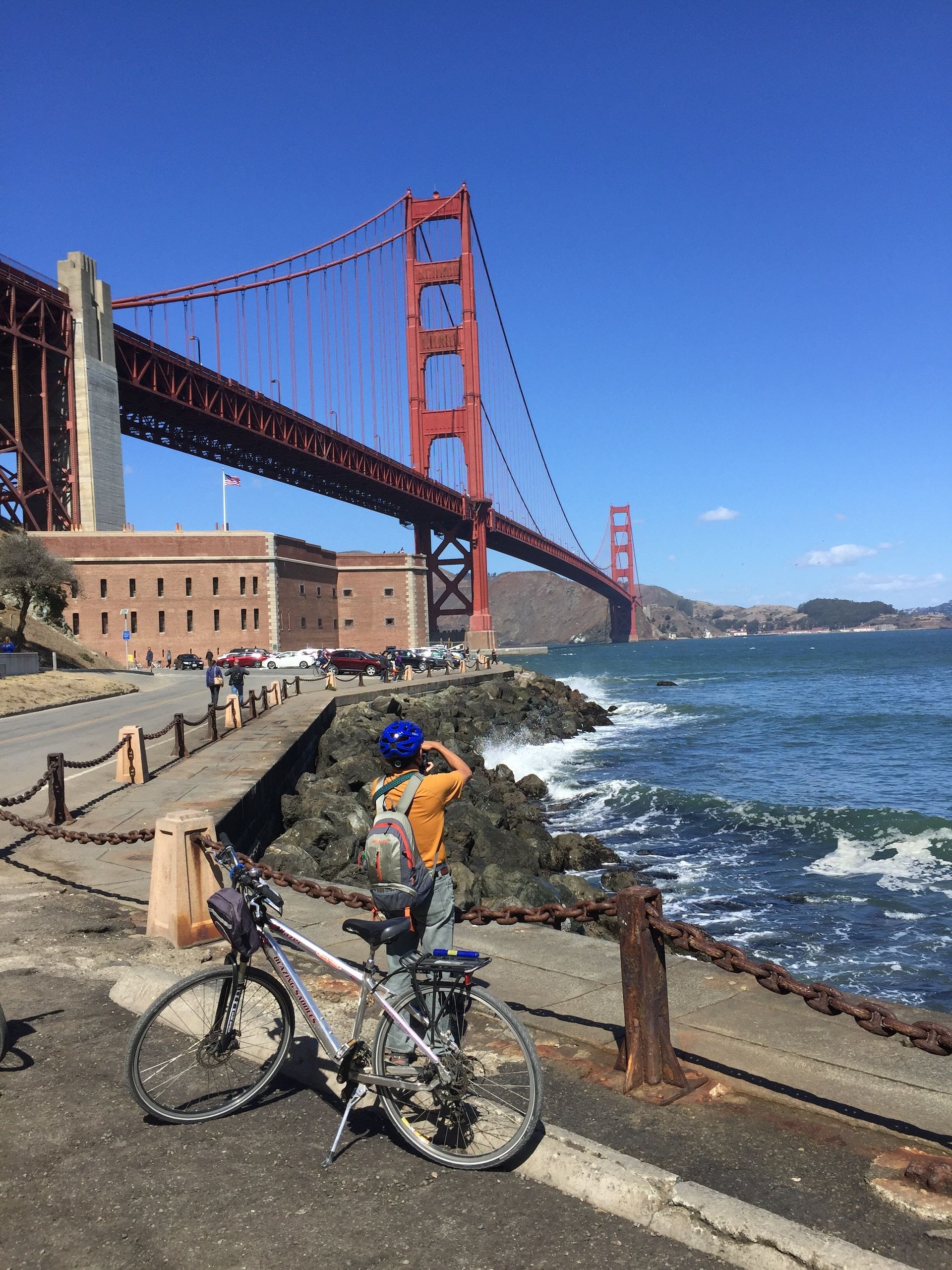 A cyclist taking a photo near the Golden Gate Bridge in SF
