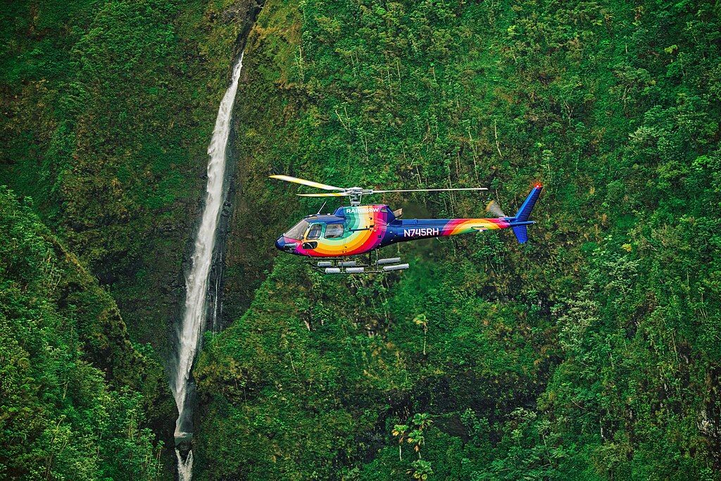 Rainbow Helicopter near a Waterfall Operating in Hawaii