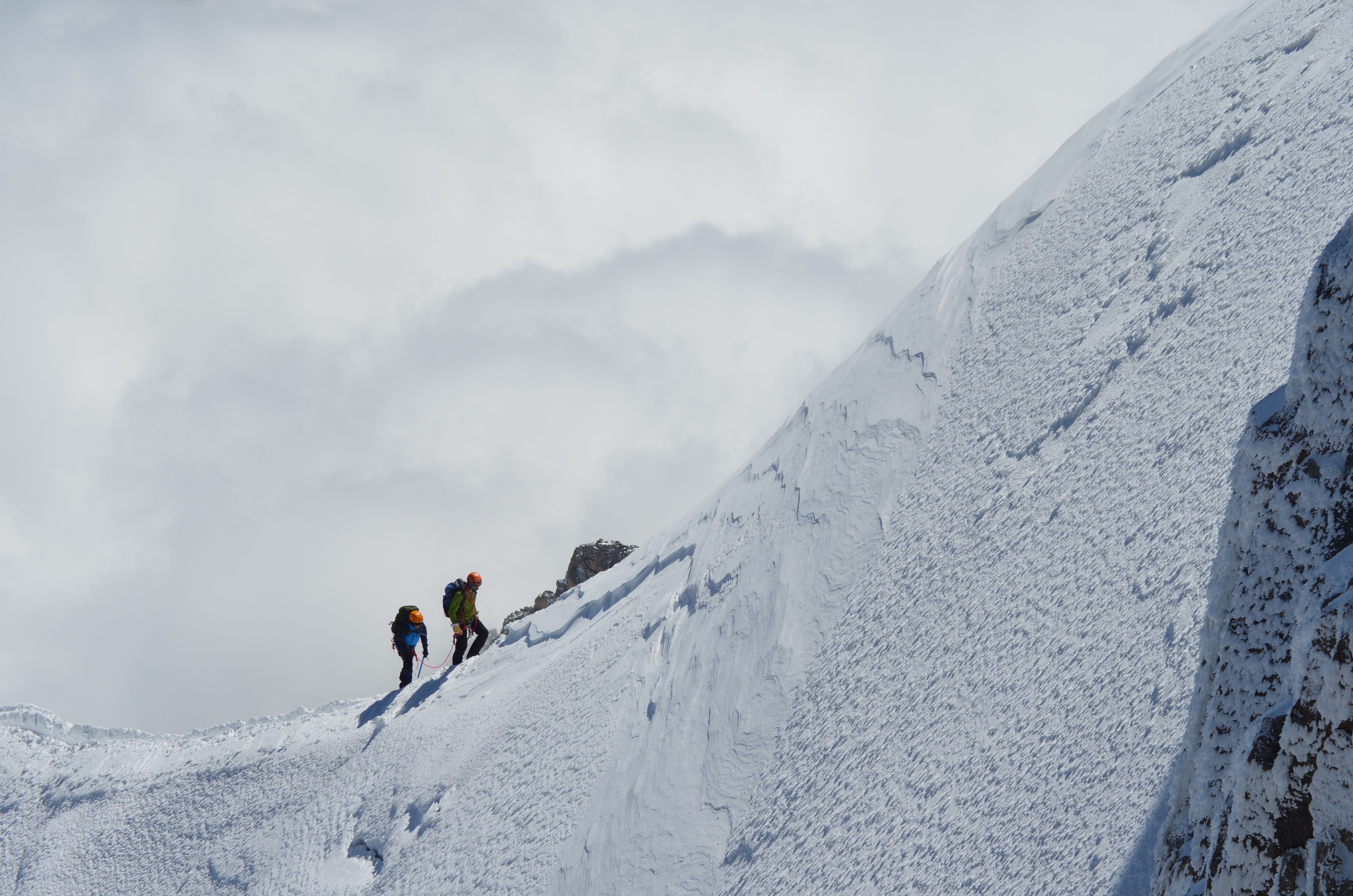 Mountaineers climbing up a snowcapped mountain