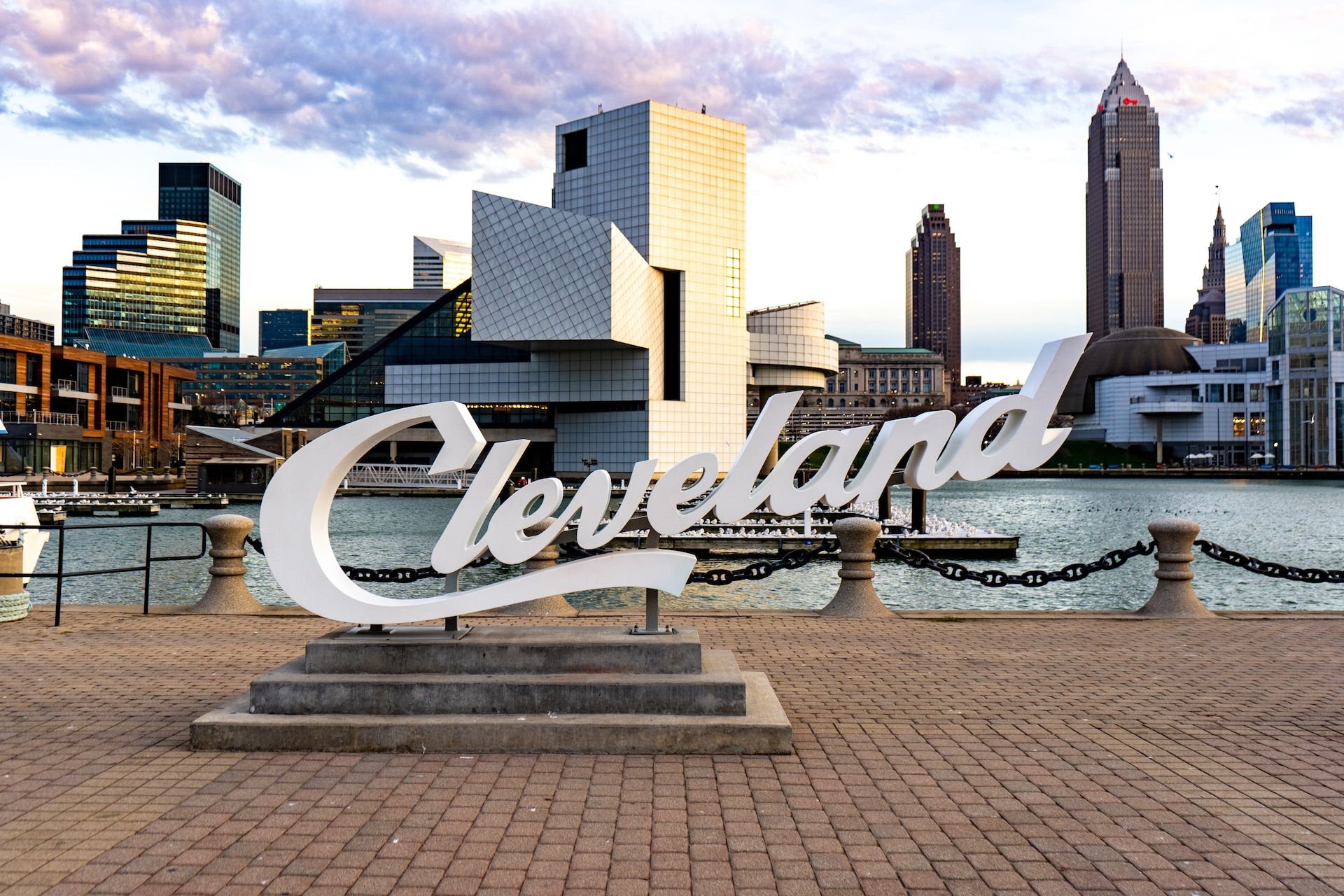 Cleveland sign in the city of Cleveland, Ohio, with structures and a water body in the background 