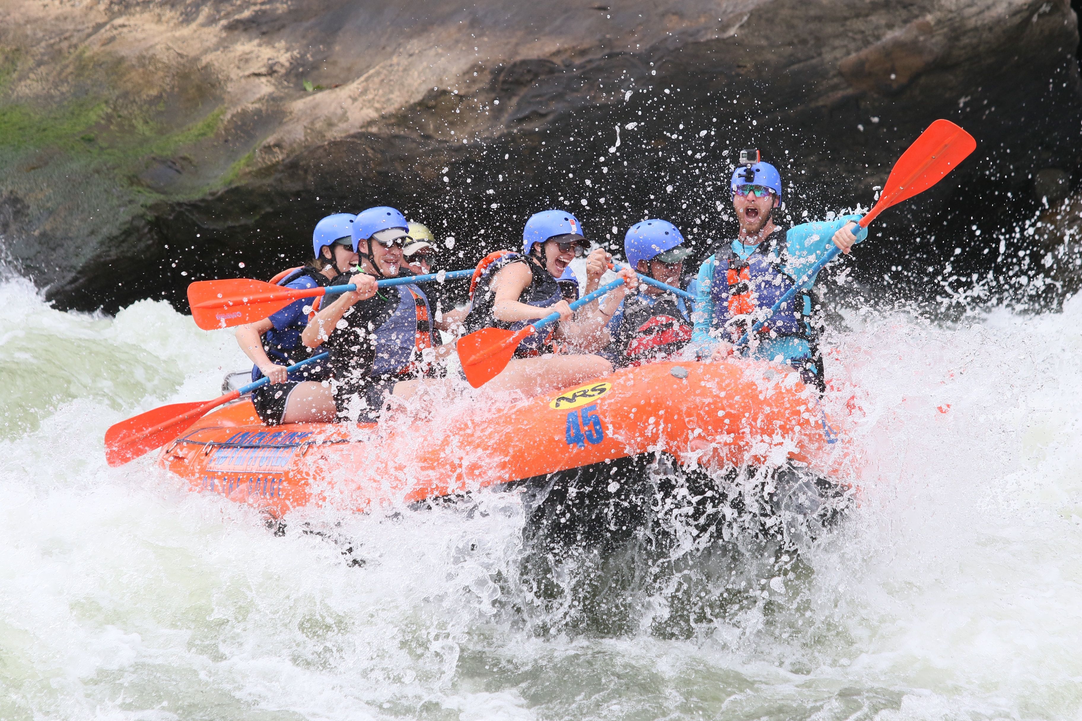 Rafters brace against a rapid on a Guided Whitewater Rafting Tour
