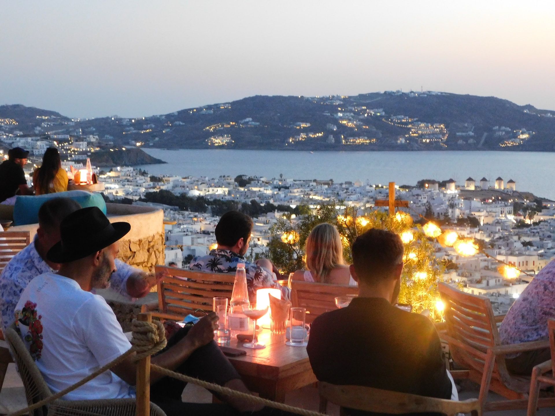 People sitting at tables at 180 sunset bar in Mykonos, Greece 