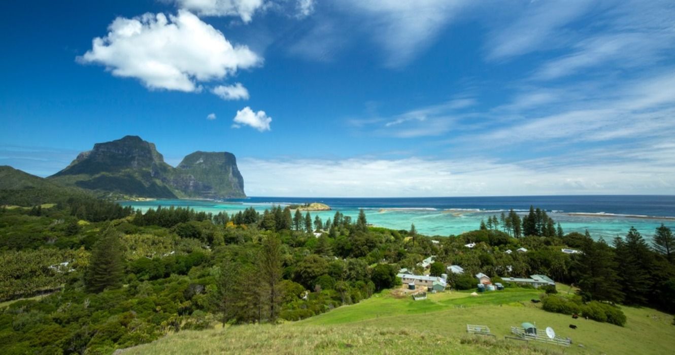Beautiful view of houses between the trees and Mount Lidgbird and Mount Gower, seen from Malabar Cliffs on Lord Howe Island, New South Wales, Australia