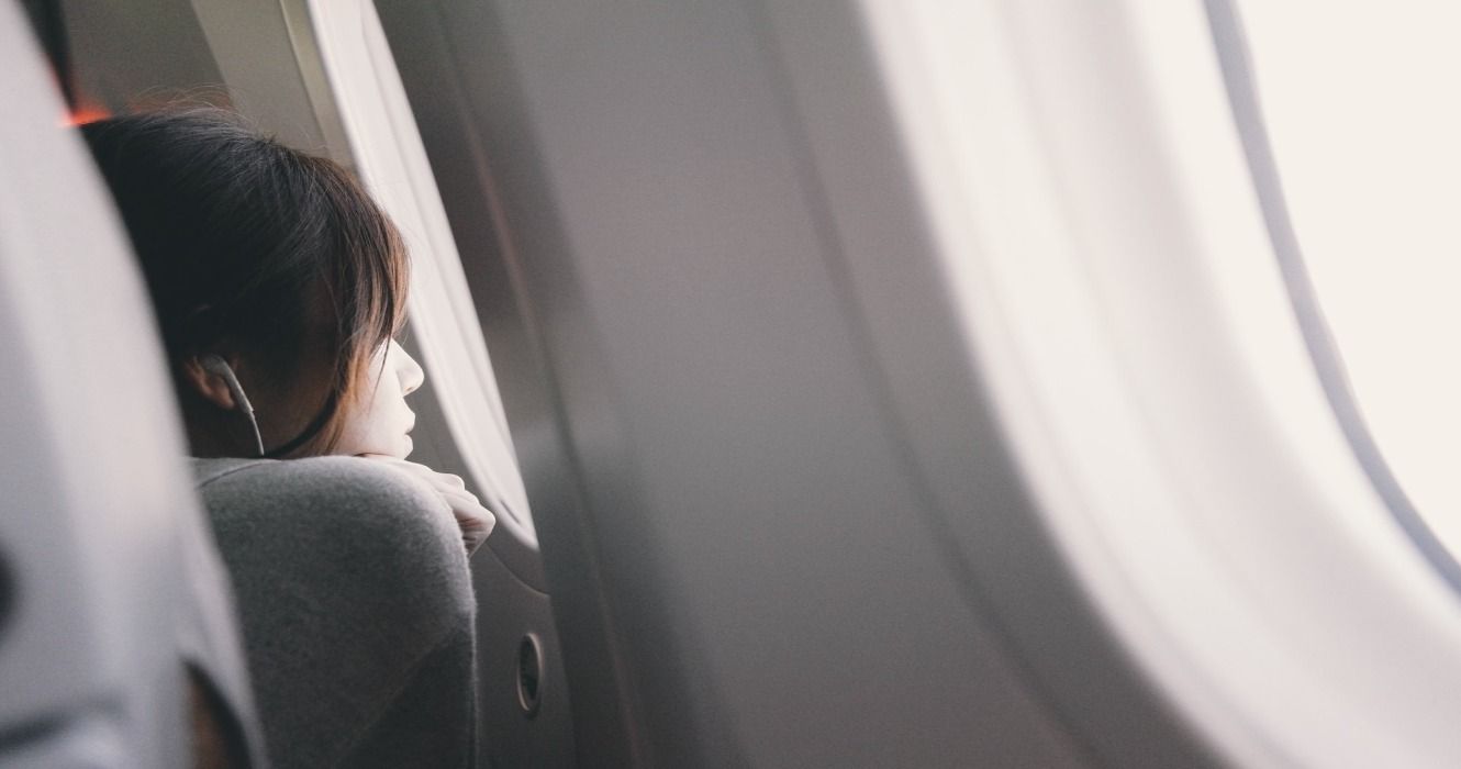 A woman looking out of a plane window