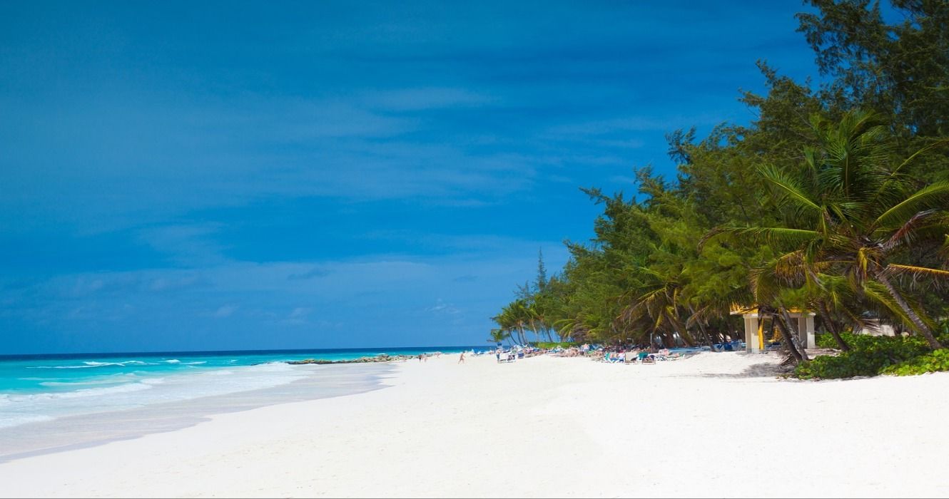 A stunning tropical beach in Barbados with white sand, palm trees, and turquoise ocean