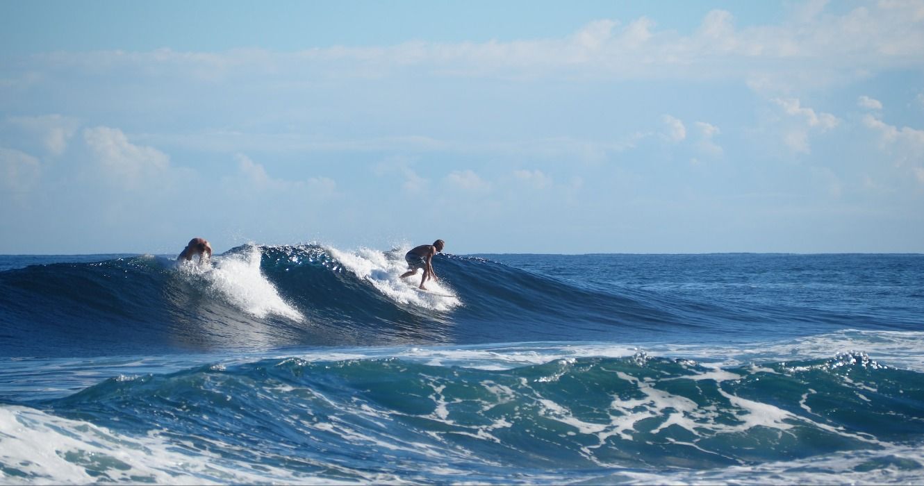 Two surfers riding a wave in Puerto Rico, Caribbean