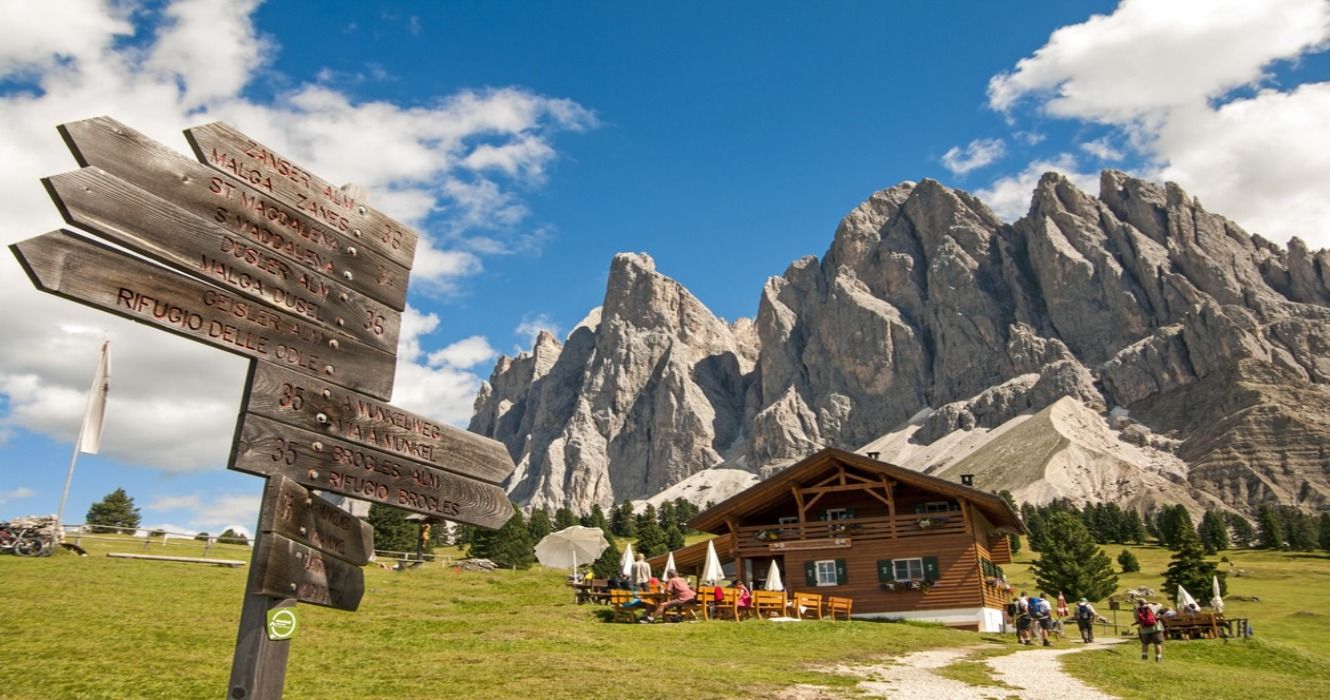 Hikers approaching a wooden cabin in Odles, South Tryol, the Dolomite Mountains, Italy