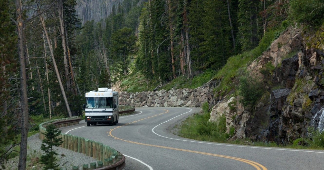 A motor home driving on a curvy section of route 14, 16, and 20 in Yellowstone National Park, Wyoming
