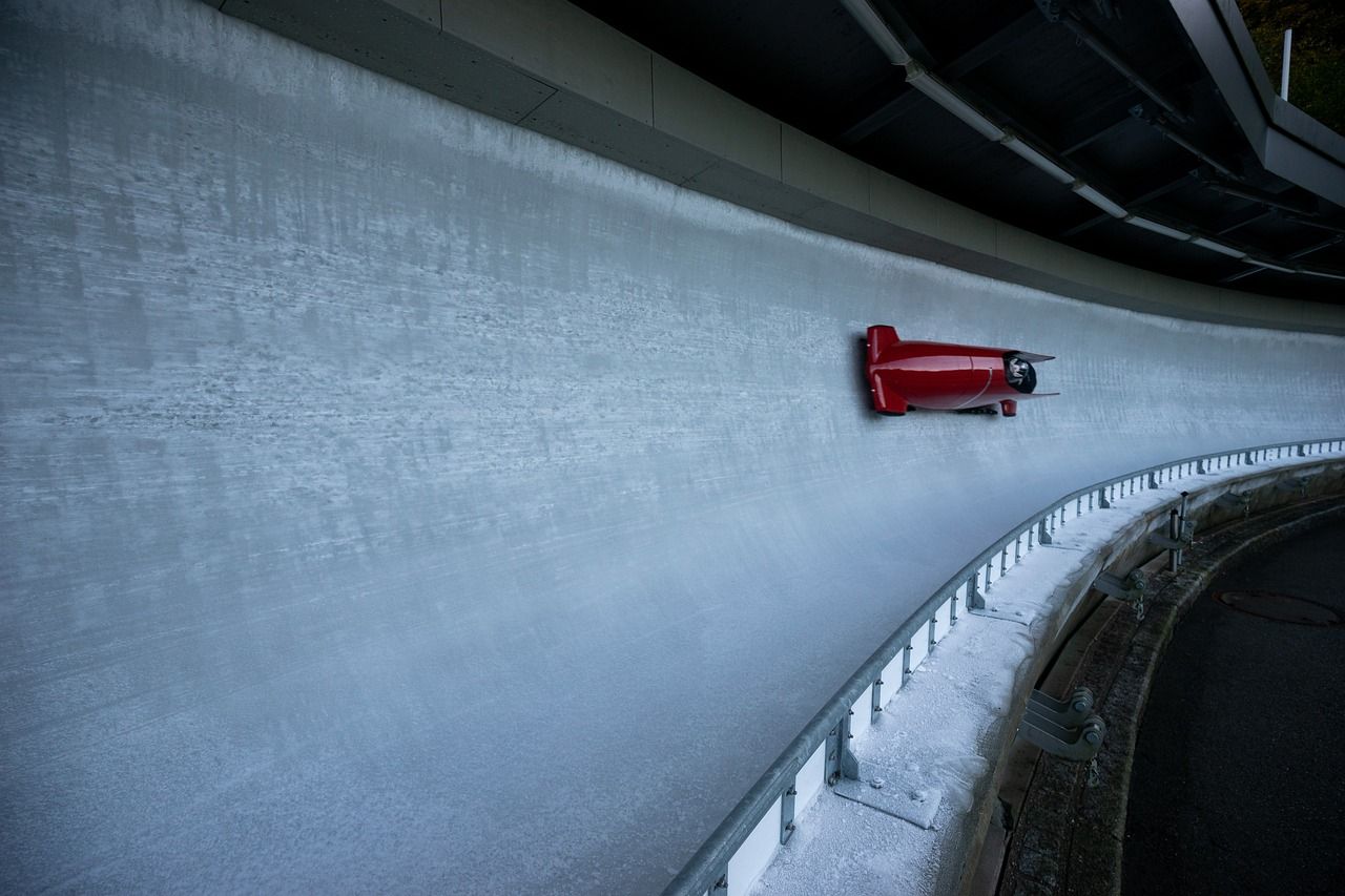 A wide shot of a bobsled shooting down an icy track