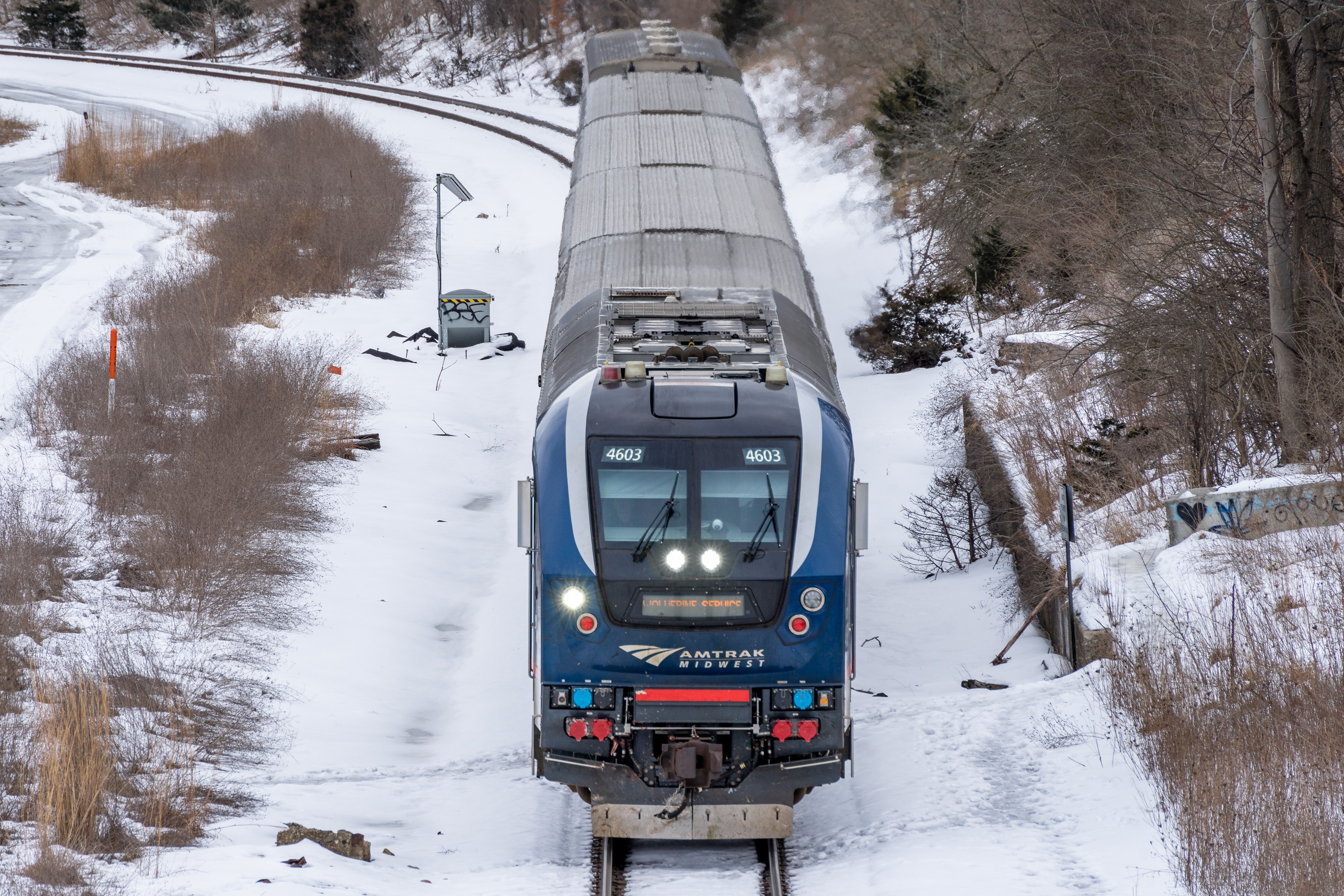 An Amtrak Train Traveling Through a Snow-Covered Countryside 