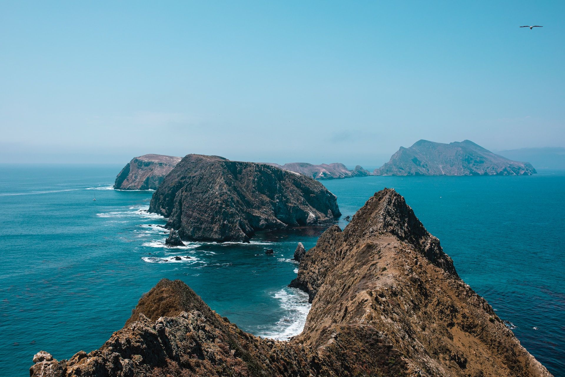 Channel Islands dotted along the Pacific coast of California with deep blue water and a bright light blue sky.