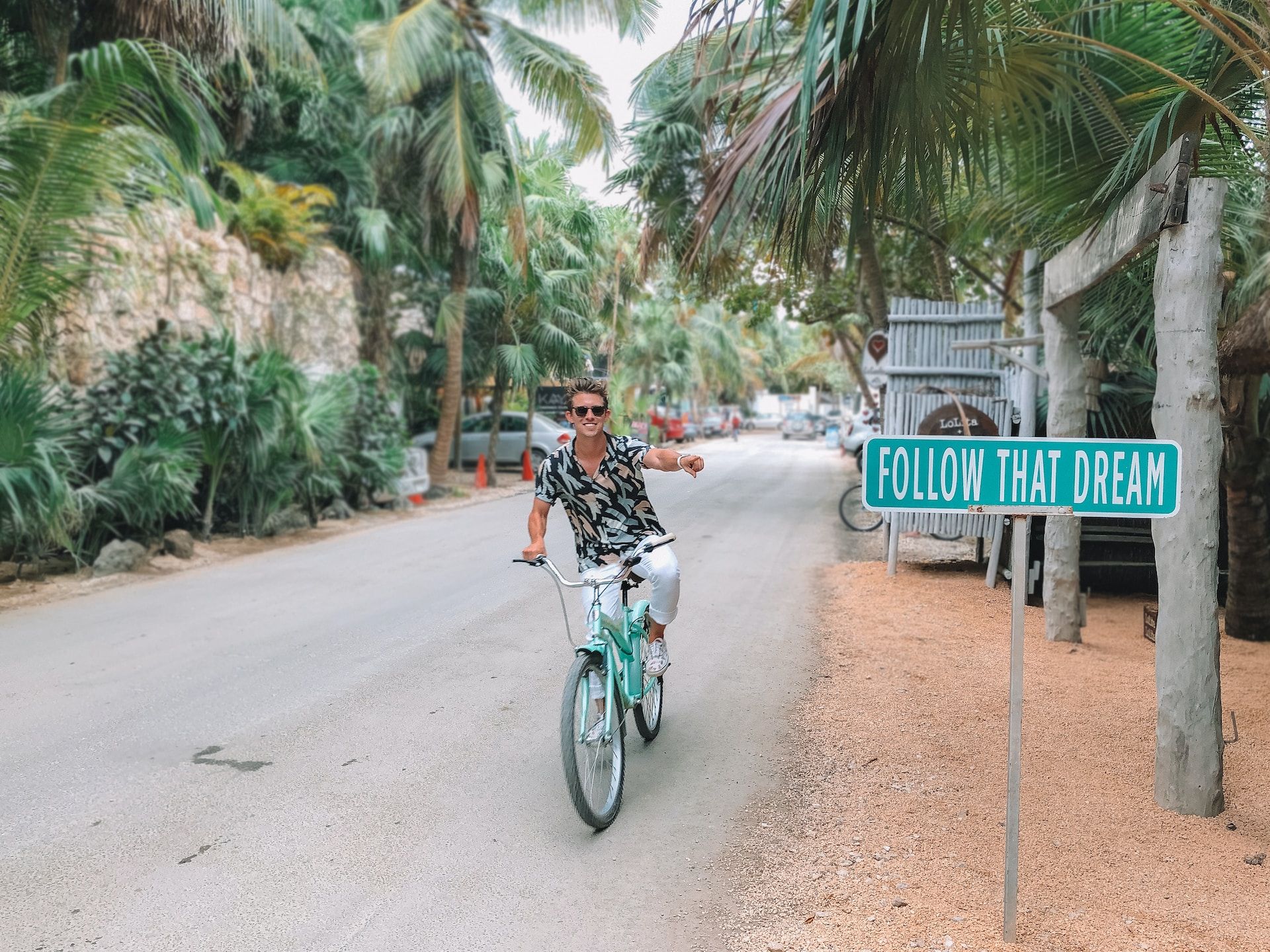 Person on a bike in Tulum Follow That Dream Sign