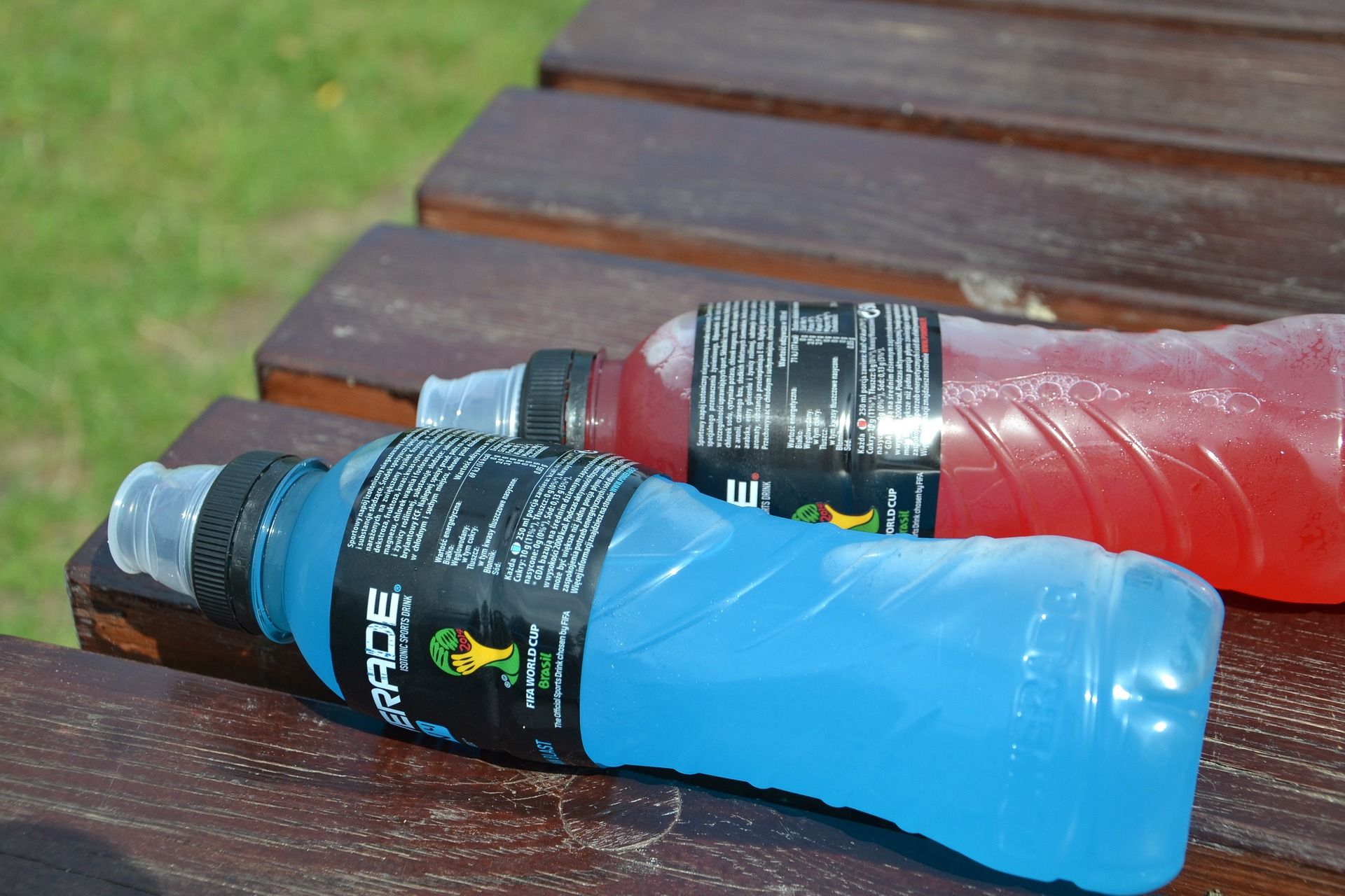 Blue and red powerade drinks on a picnic table