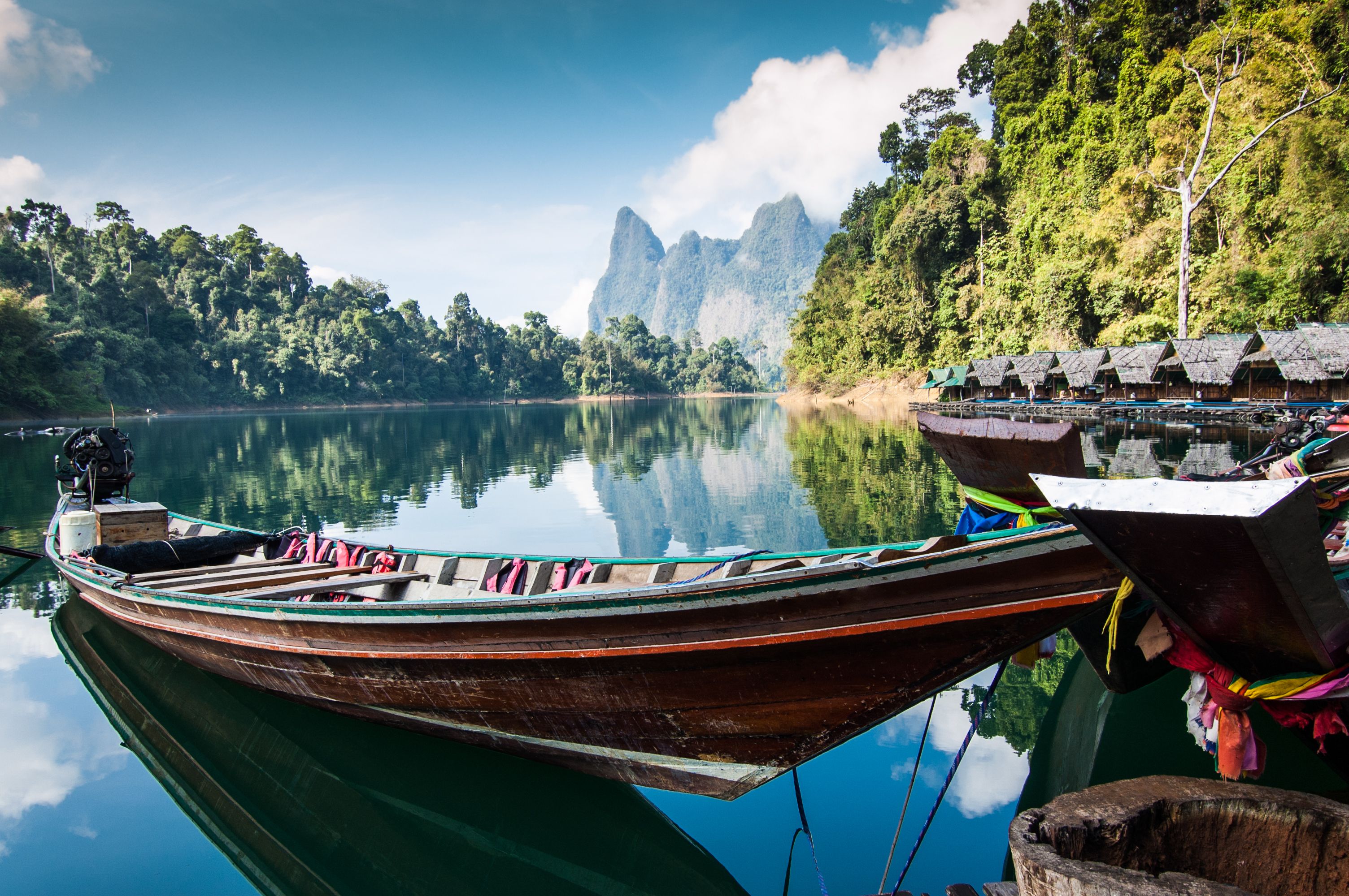 Long-tail boat and lakeside raft houses on Cheow Lan Lake in Khao Sok National Park in Southern Thailand
