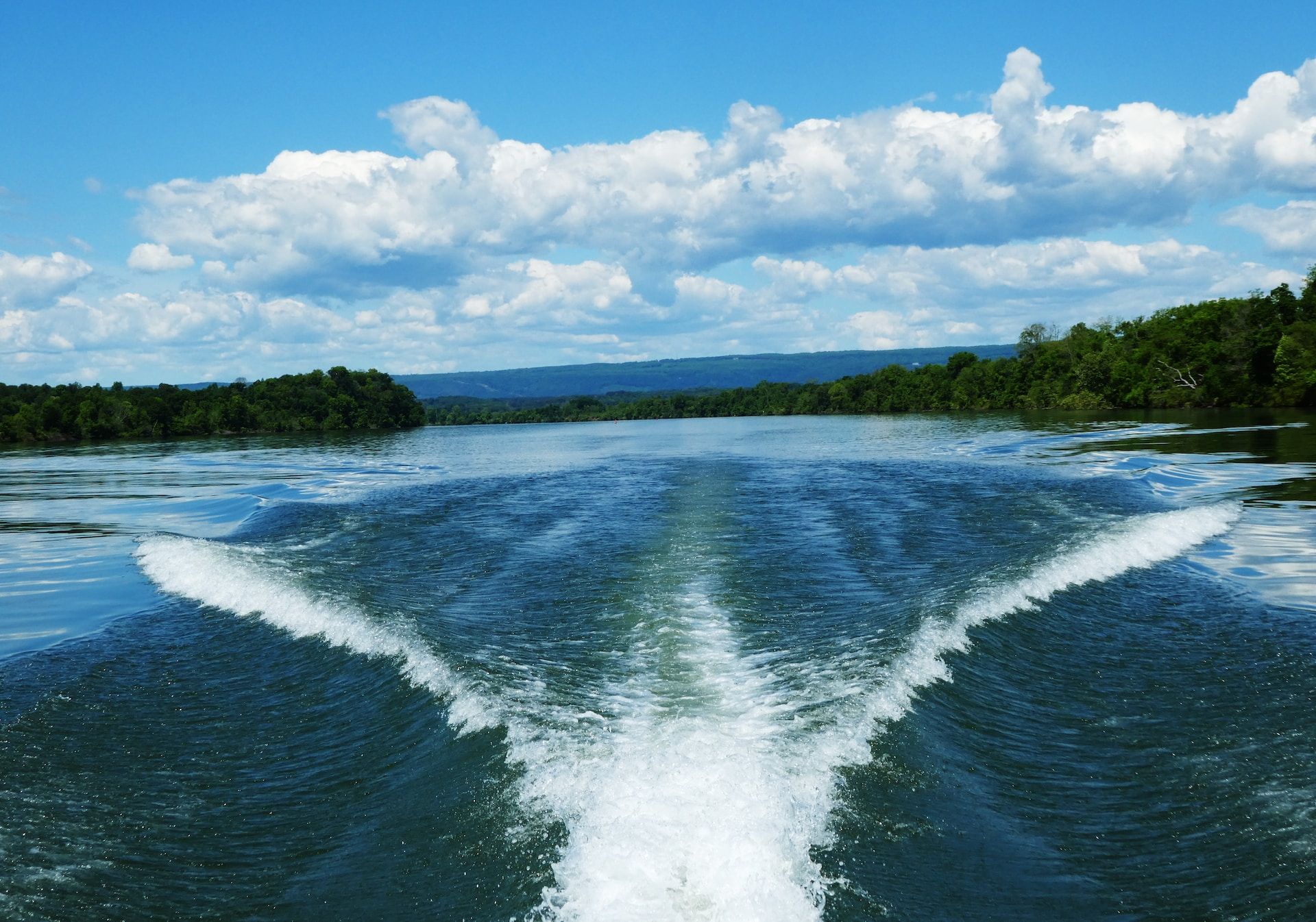 A boat leaving a wake on a large body of water.