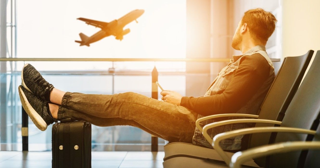 A  traveler waiting for his flight at the airport