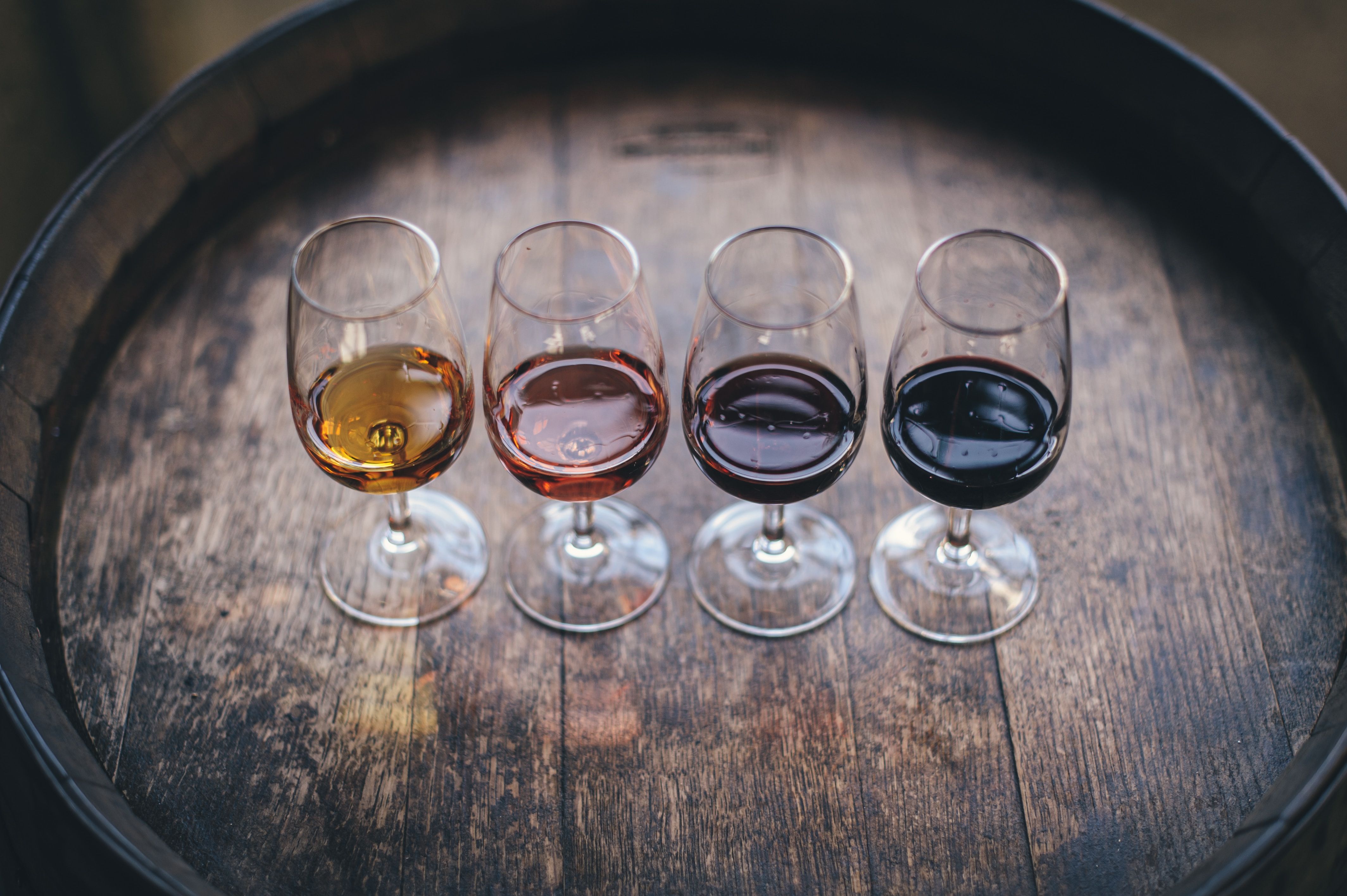 A selection of glasses of wine on a barrel, perfect for wine tasting