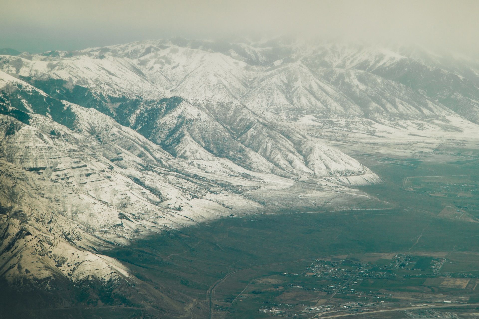 An aerial shot of snow-capped mountains surrounding Salt Lake City, Utah