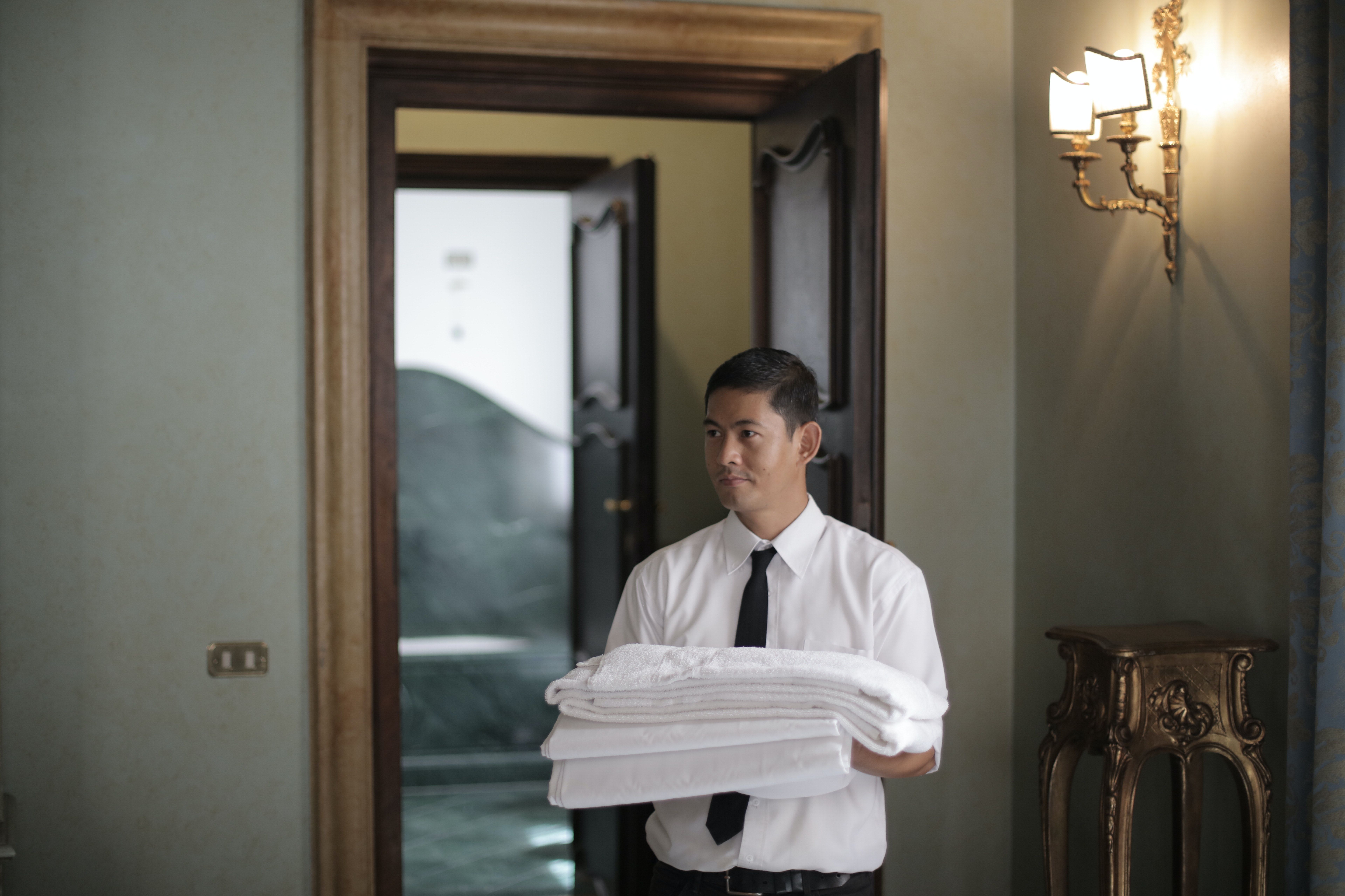 Hotel staff with bed linen