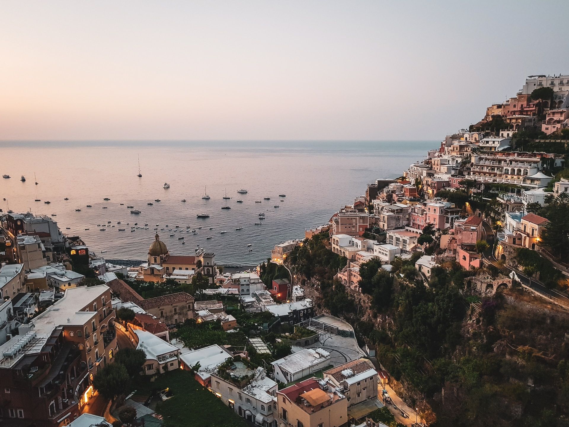 An aerial view of the coastal town of Positano at dusk on the Amalfi Coast