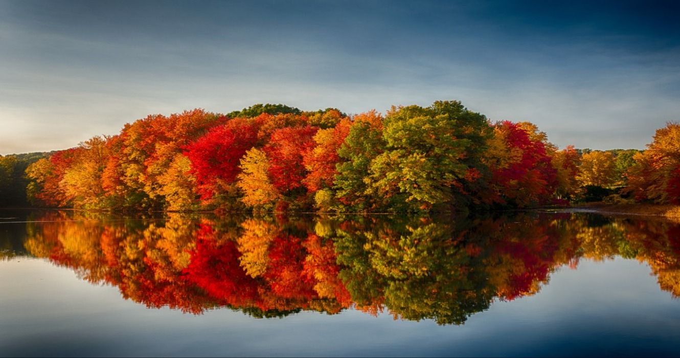 Fall foliage in Massachusetts reflecting against a pond, New England, USA