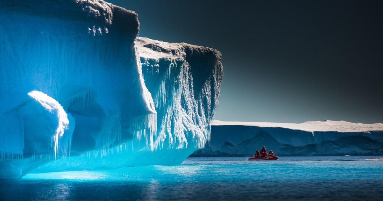 Scientists exploring icebergs in Antarctica, the Antarctic Ocean, in a boat