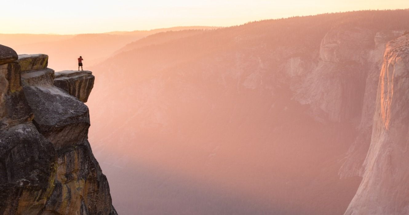 A hiker or rock climber at the edge of a cliff at Taft Point overlooking El Capitan, Yosemite National Park, California, USA