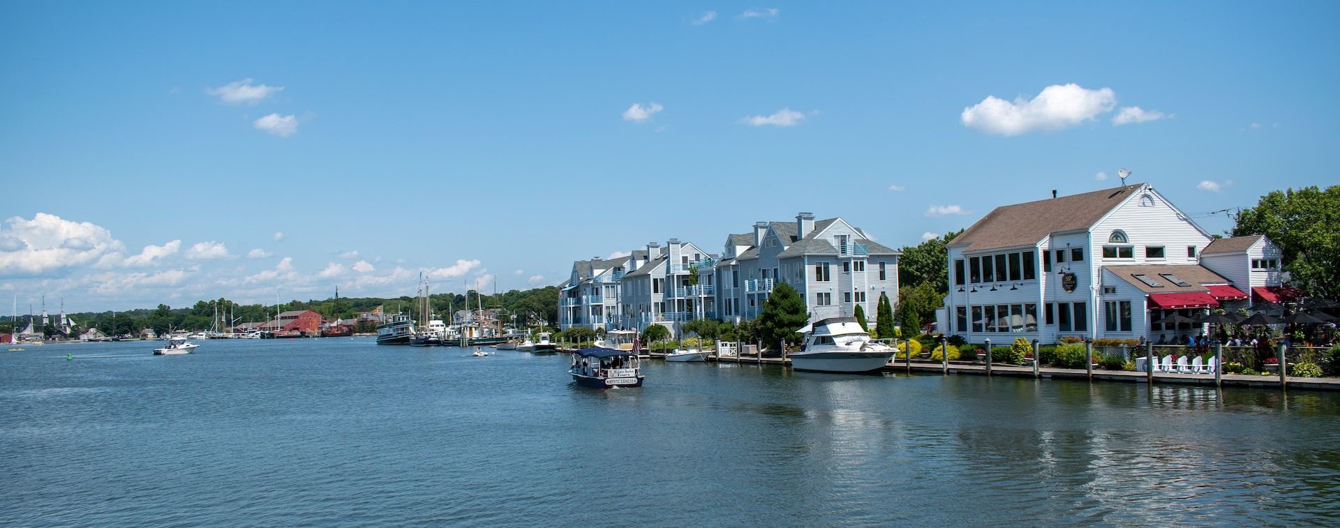 Boats cruising up the Mystic River in southeast Connecticut toward The Mystic Seaport