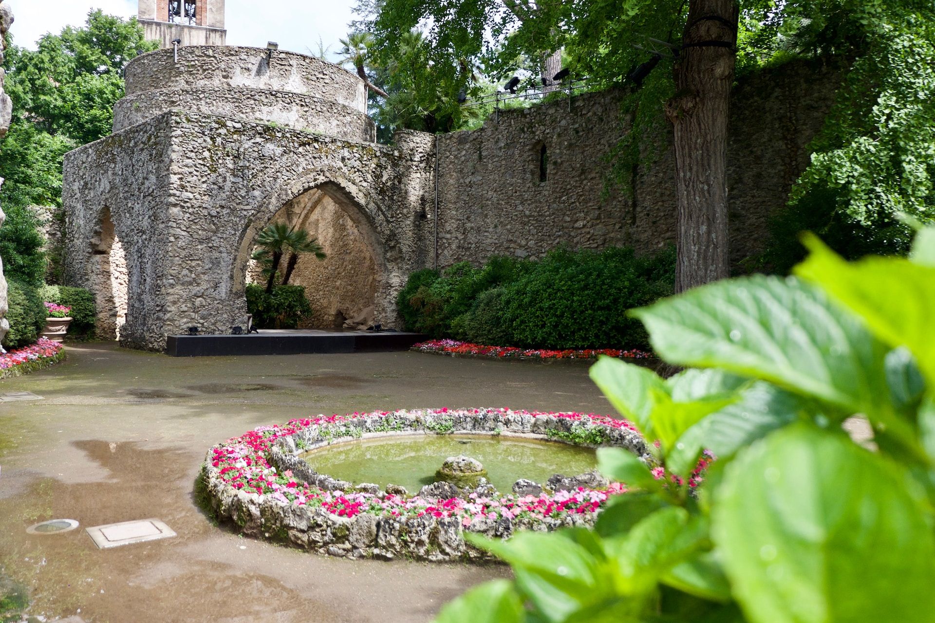 Quiet gardens with a fountain surrounded by medieval walls in Villa Rufolo