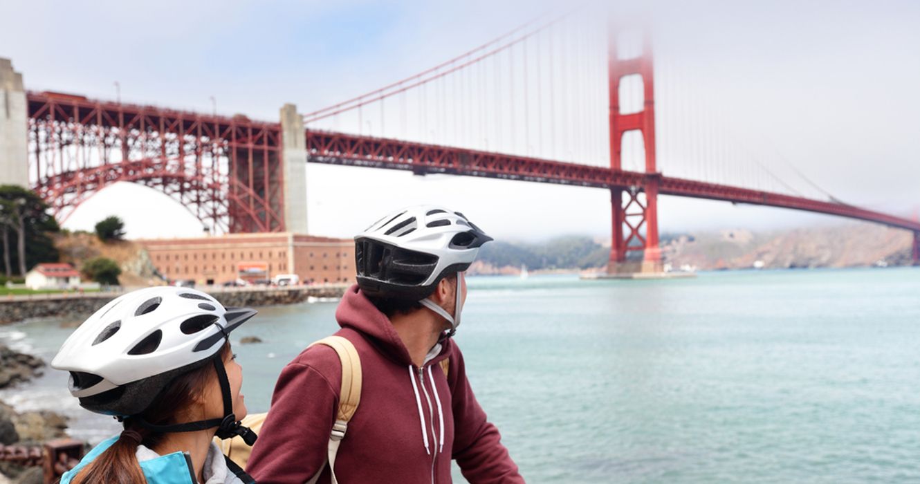 A couple biking by the Golden Gate Bridge in San Diego, California, USA