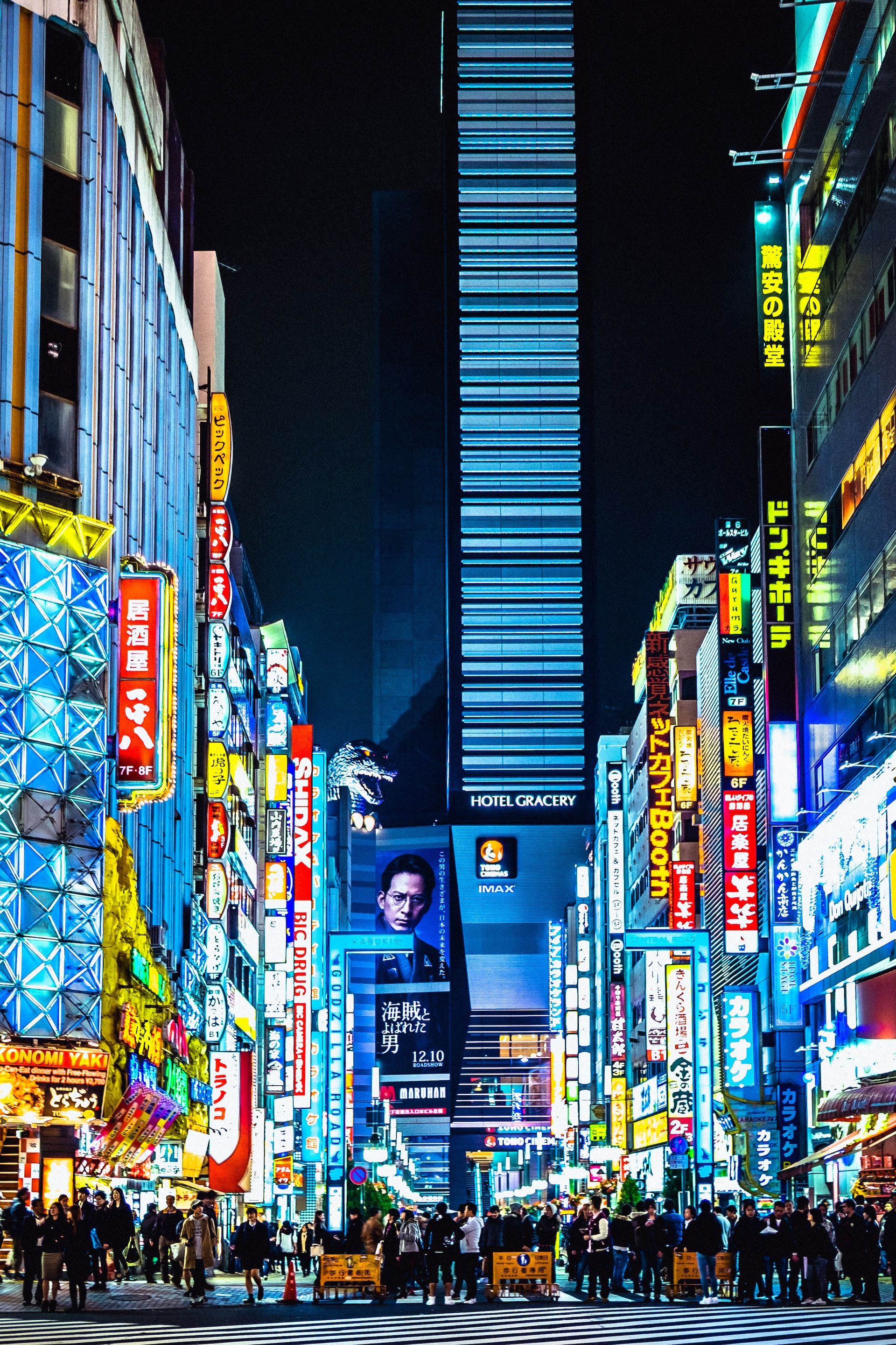 Street view of Tokyo lit up at night with people along, Japan 