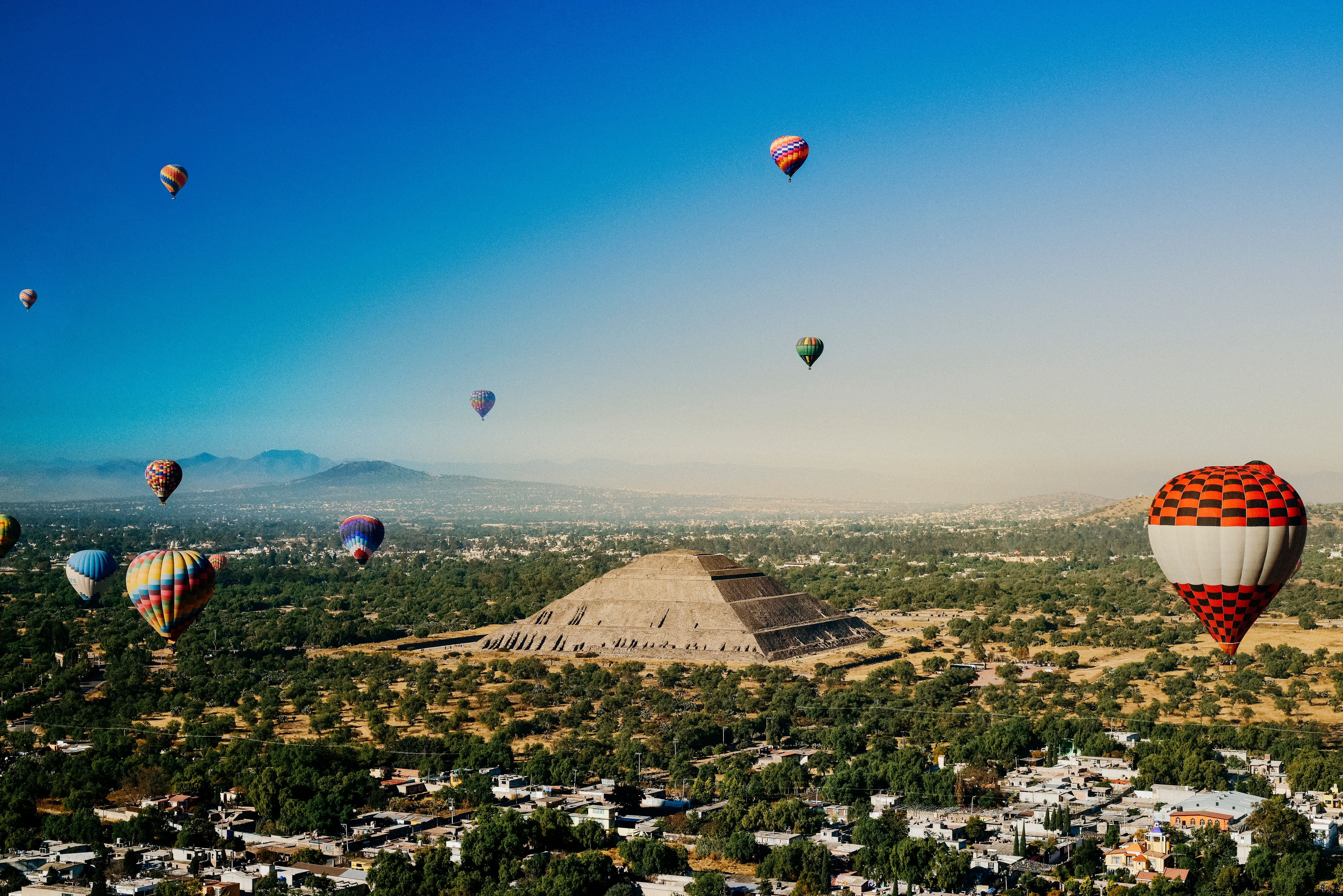 Sunrise with hot air balloons flying over the pyramid of the Sun, in Teotihuacan, Mexico
