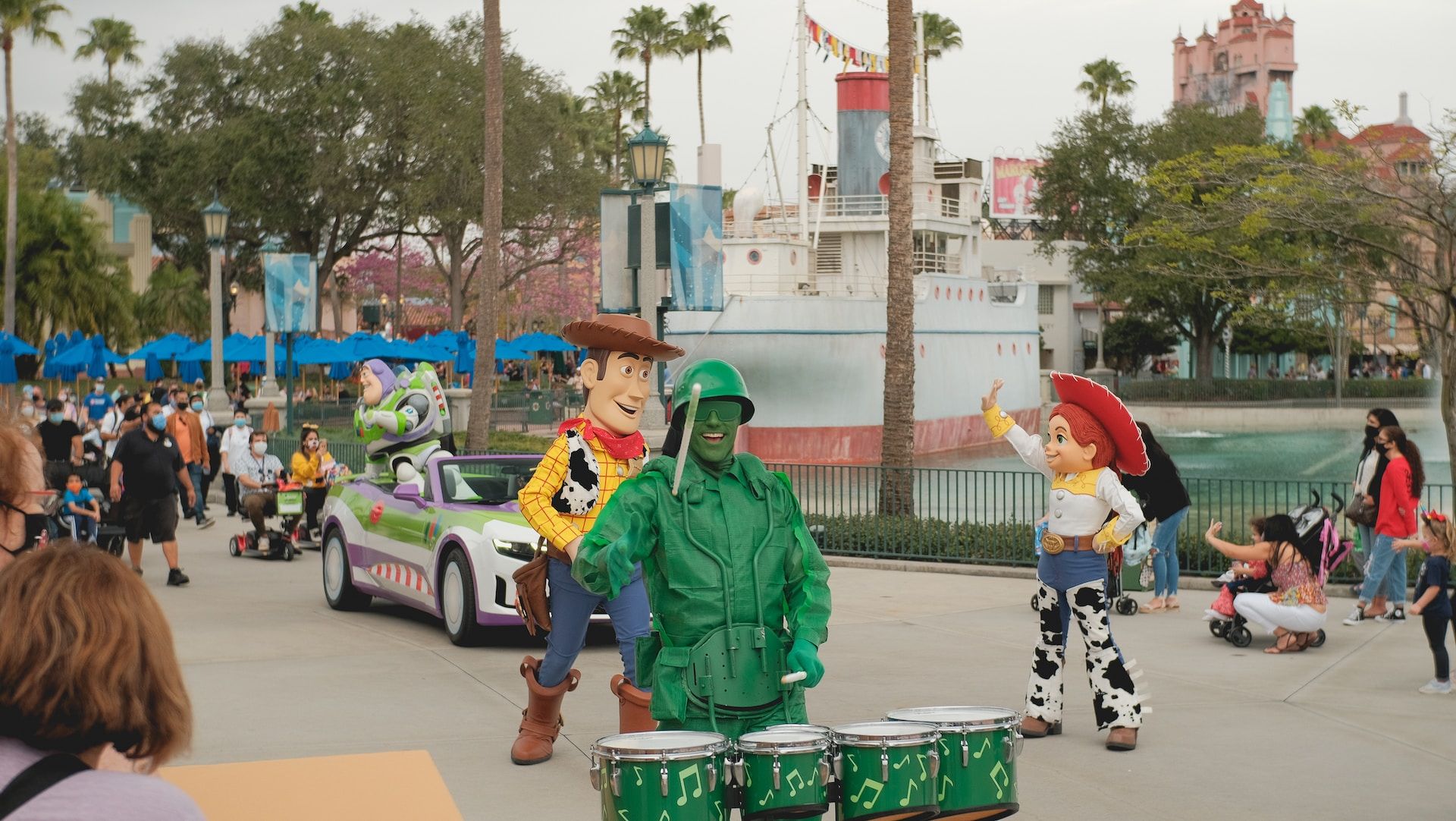 Man In Green Jacket With Several Other People In The Background At Disney World, Orlando, FL, USA