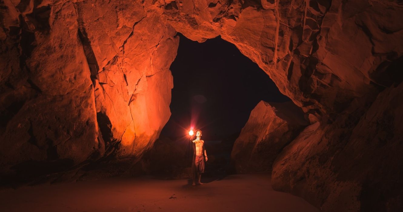 Person with a red light inside a cave