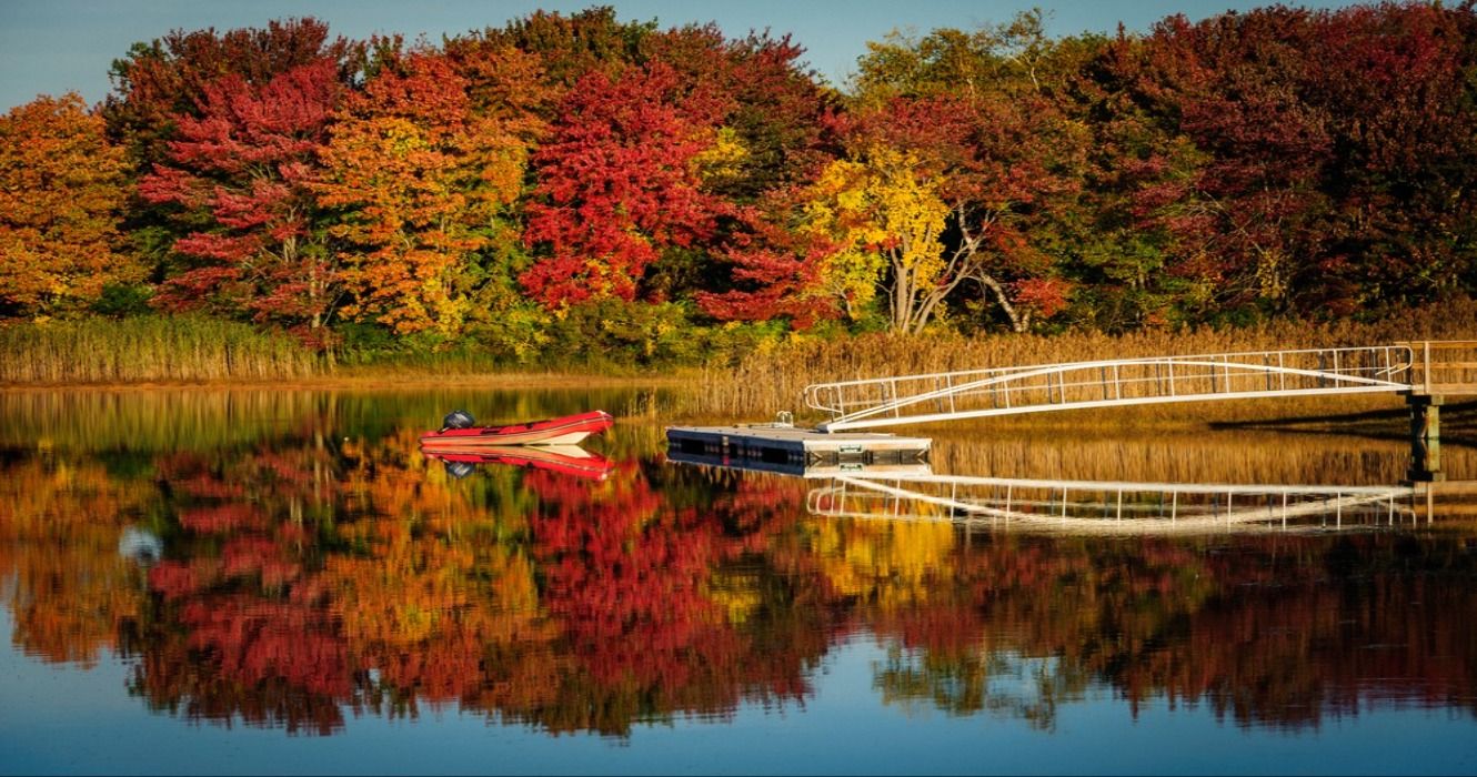 Dinghy on lake surrounded by fall foliage in the autumn near Kennebunkport, Maine, USA