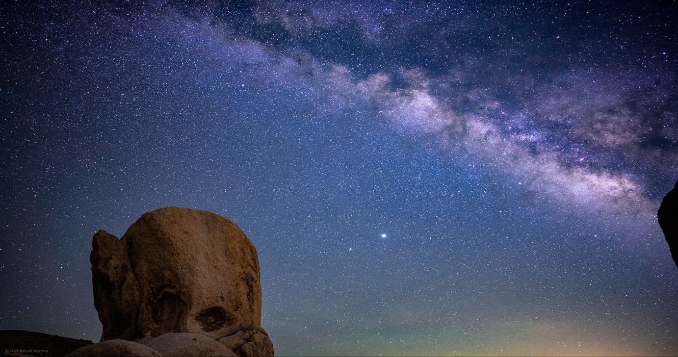 A Milky Way starry night sky and rocky landscapes at the Galactic Center in Joshua Tree National Park, California, USA