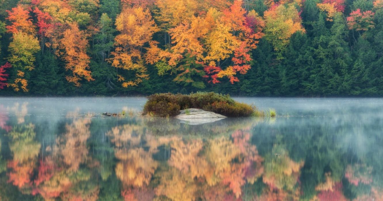 Autumn colors and fall foliage surrounding a lake in Muskoka, Ontario, Canada