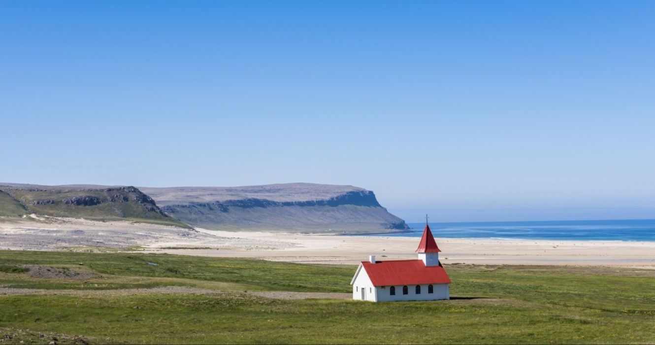 Little church with a red roof on the beach at Breidavik Beach in Iceland