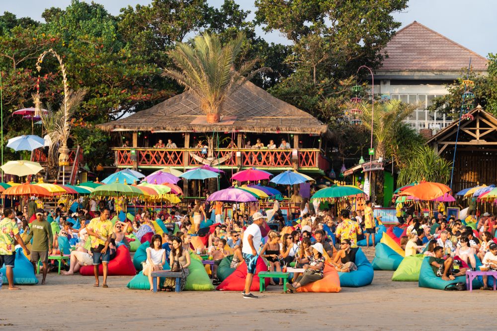 Large crowds of tourists at a beach bar on Seminyak beach near Kuta in Bali, Indonesia