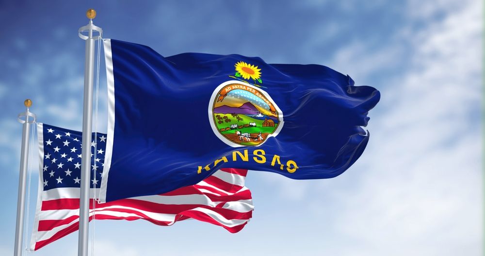 The Kansas state flag waving with the national flag of the United States of America